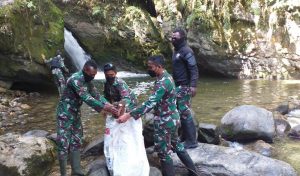 Peduli Lingkungan, Satgas Pamrahwan Bersihkan Lokasi Wisata Air Terjun Walesi