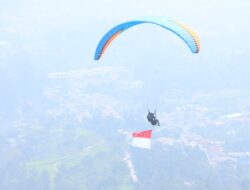 Polres Bogor Kibarkan Bendera Merah Putih Melalui Penerbangan Paralayang