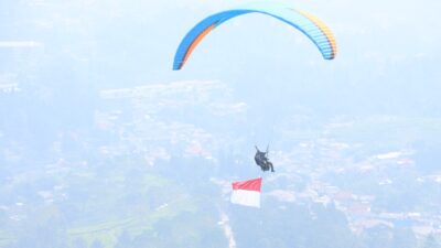 Polres Bogor Kibarkan Bendera Merah Putih Melalui Penerbangan Paralayang