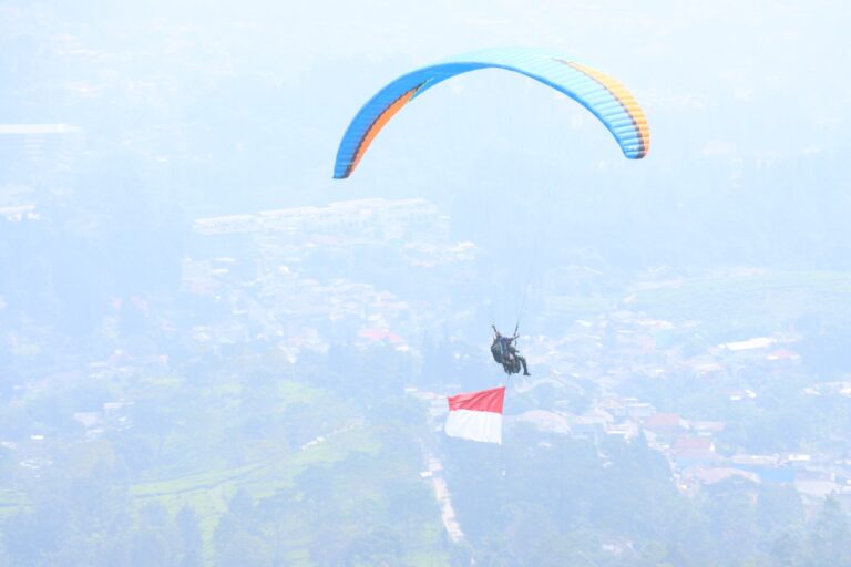 Polres Bogor Kibarkan Bendera Merah Putih Melalui Penerbangan Paralayang