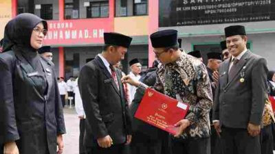 Bupati Bandung Dadang Supriatna menyematkan tanda kehormatan pada Upacara HAB 80 Kemenag di Baleendah.